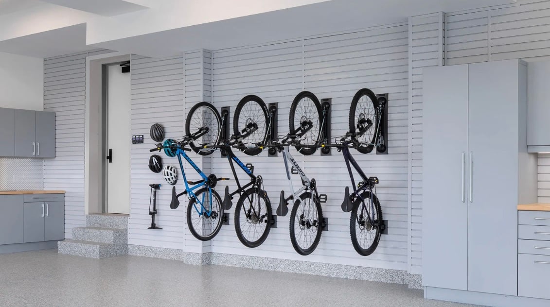 Bikes on garage slatwall hanging by wheels - Garage Living solutions