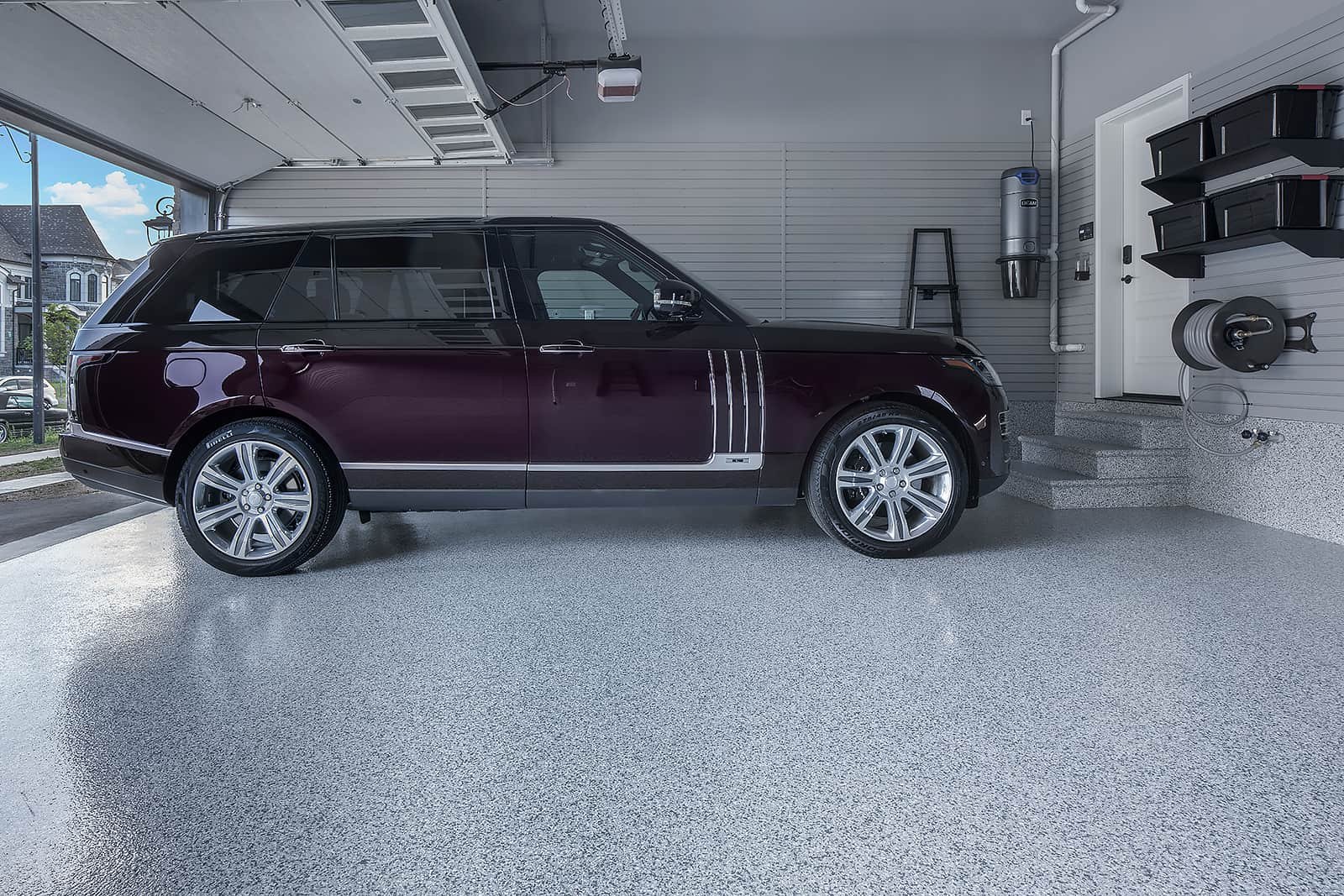 A two-car garage with a Range Rover parked on a floor coated in a sleek, durable garage floor coating - Garage Living