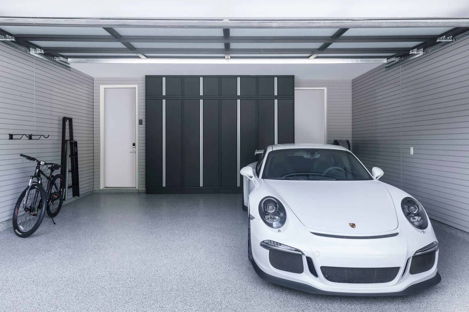 Minimalistic Garage with storage cabinetry and Porsche GT3 - Garage Living
